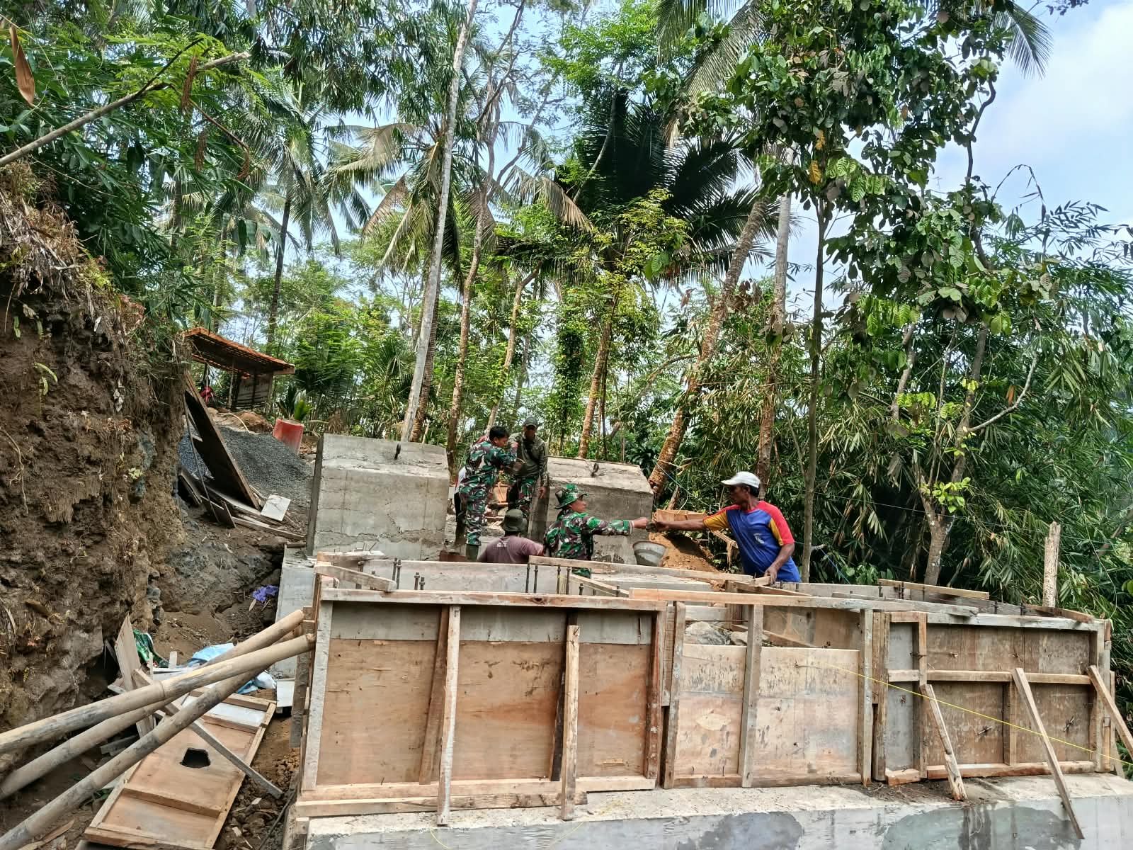 Panas Terik Matahari, TNI dan Warga Tetap Semangat Bangun Pondasi Jembatan Garuda