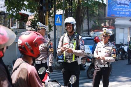 Polres Gresik Bagikan Bendera dan Pin Merah Putih di Jalan Tanamkan Se